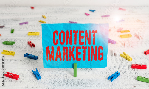 Word writing text Content Marketing. Business photo showcasing involves the creation and sharing of online material Green clothespin white wood background colored paper reminder office supply