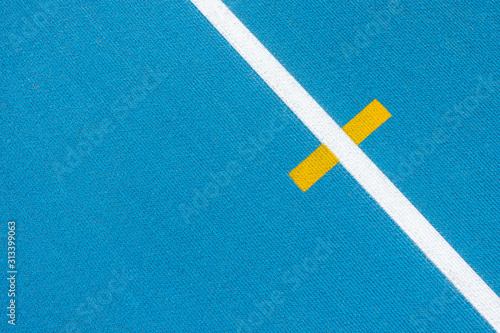 Sport background. Blue running track with white lines and yellow mark in sport stadium. Top view