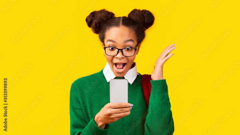 Happy afro teenager reading good news on phone Happy afro teenager reading good news on phone