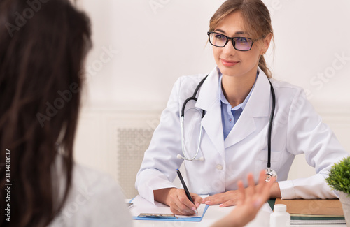 Woman Visiting Female Physician Sitting In Clinic Office