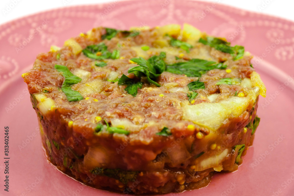 Beef Tartare cold appetizer of raw minced meat with egg yolk, spices, onions, olive oil, lemon juice Beef Tartare cold appetizer of raw minced meat with egg yolk, spices, onions, olive oil, lemon juice