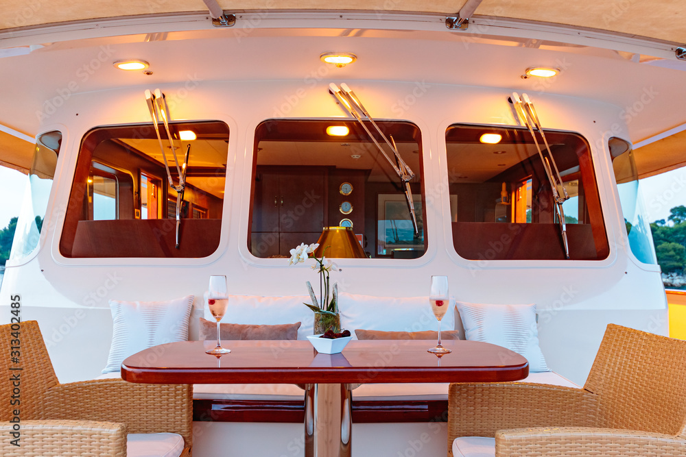 Wooden table with two champagne glasses on the yacht Wooden table with two champagne glasses on the yacht