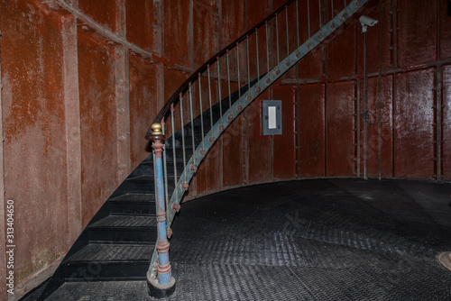 Old lighthouse on the inside. Red iron spiral stairs, round window and blue wall. Hiiumaa, small island in Estonia. Europe