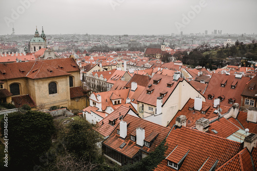 Panorama of Prague with red roofs and Church. City view of Praha old city. Rustic grey colors toning.