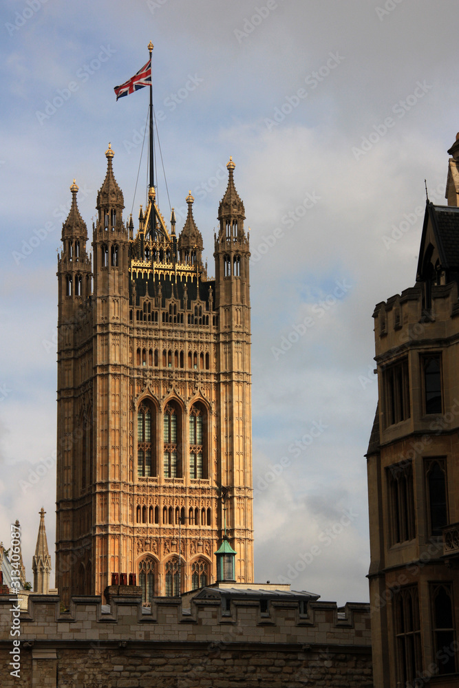 British flag waving on top of the Victoria Tower at the Westminster Palace in London, United Kingdom British flag waving on top of the Victoria Tower at the Westminster Palace in London, United Kingdom