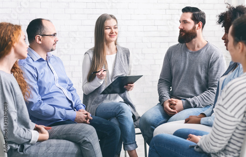 Psychotherapist talking to addicted patients in office