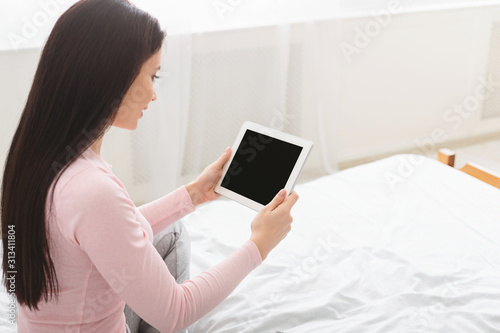 Millennial woman watching video online on blank digital tablet