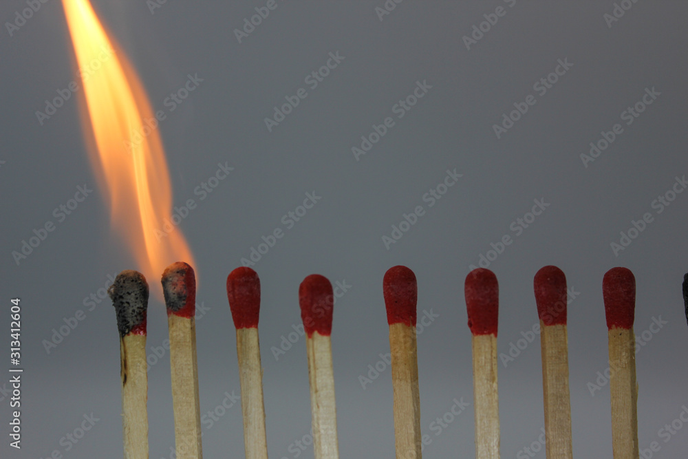 row if matches being lit by flame in a chain reaction row if matches being lit by flame in a chain reaction