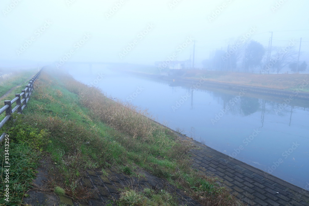 冬の朝霧の放水路風景