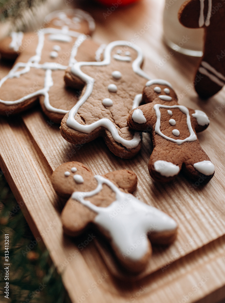 painted gingerbread man Christmas gingerbread cookies lie on a wooden board. painted gingerbread man Christmas gingerbread cookies lie on a wooden board.