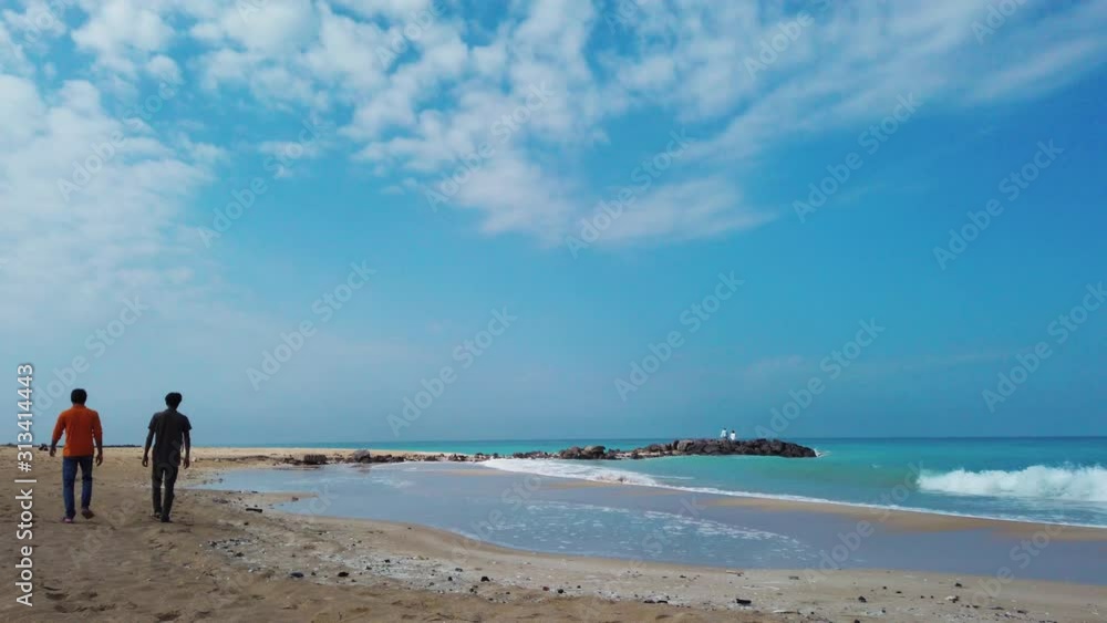 Togetherness concept, two men walking along beach, Back rear view, Dubai, United Arab Emirates Togetherness concept, two men walking along beach, Back rear view, Dubai, United Arab Emirates