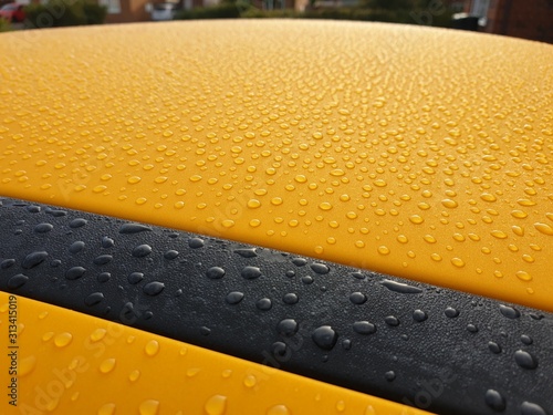 Fototapeta Beading water on yellow car