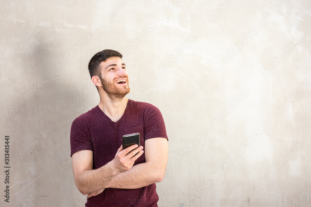 smiling young man with beard holding mobile phone smiling young man with beard holding mobile phone