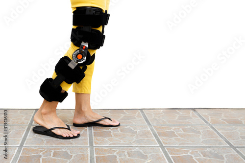 Photography Woman leg in an orthosis standing on the floor isolated.