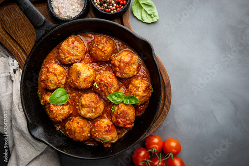 Meatballs with spicy tomato sauce on a frying pan, view from above, top view