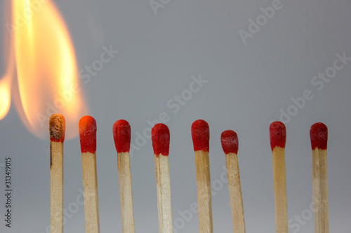 row if matches being lit by flame in a chain reaction
