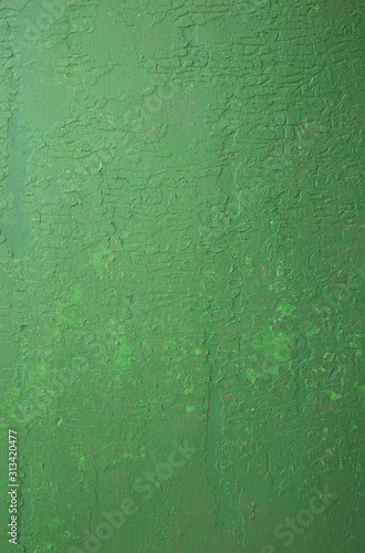 Old peeling paint on the wall. Green abstract background. Beautiful green textured stucco on the wall..Background from green stucco.