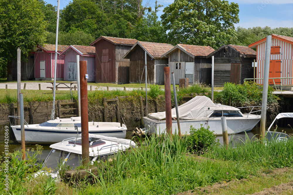 Boats in the ostreicole harbor and wooden houses of Biganos, commune is a located on the shore of Arcachon Bay, in the Gironde department in southwestern France Boats in the ostreicole harbor and wooden houses of Biganos, commune is a located on the shore of Arcachon Bay, in the Gironde department in southwestern France