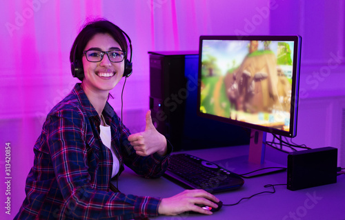 Addicted female gamer showing thumb up, playing game