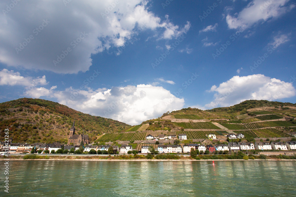 Beautiful German landscape with tiered vineyard and village seen from the middle Rhine River. Beautiful German landscape with tiered vineyard and village seen from the middle Rhine River.