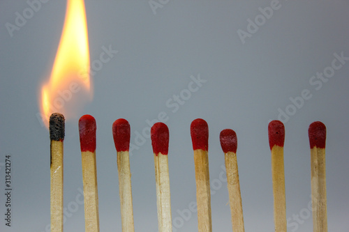row if matches being lit by flame in a chain reaction