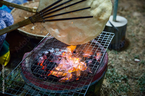 Khao Kriap Wow, thai dessert as thin flour flapped cook over the fire, focus selective. photo