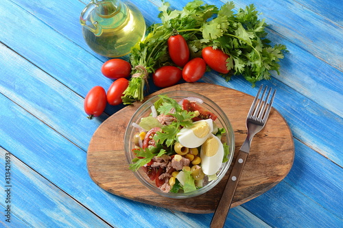 Tuna salad with lettuce, eggs and tomatoes, cucumber, corn and red onion. Healthy Mediterranean food concept photo