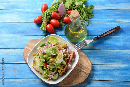 Tuna salad with lettuce, eggs and tomatoes, cucumber, corn and red onion. Healthy Mediterranean food concept photo