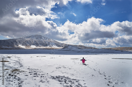雪原で遊ぶ子供。九州・熊本・阿蘇山・草千里