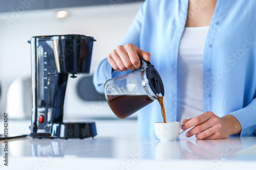 Fotobehang Woman using coffee maker for making and brewing coffee at home