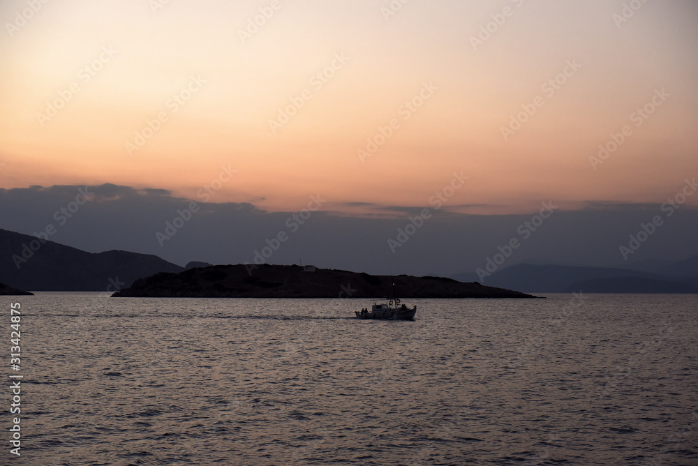 Boat against sea and mountain landscape at dusk