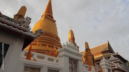 Camera pans to the top of a beautiful golden stupa in Buddhist temple in Bangkok, Thailand. (ID: 313425048)