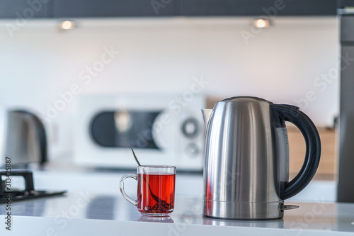 Electric kettle for boiling water and making tea on a table in the kitchen interior. Household kitchen appliances for makes hot drinks