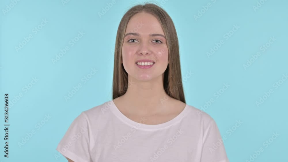 Beautiful Young Woman Pointing Finger at the Camera, Blue Background Beautiful Young Woman Pointing Finger at the Camera, Blue Background