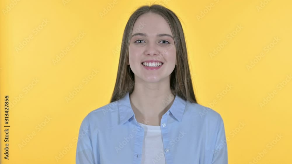 Casual Young Woman Saying Yes by Head Shake, Yellow Background Casual Young Woman Saying Yes by Head Shake, Yellow Background