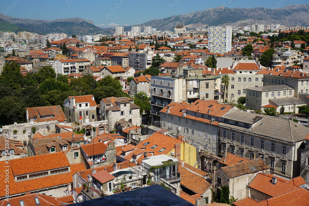View of the northwestern part of Split from the bell tower of the Split Palace. Tiled roofs of old houses, modern high-rise buildings, mountains in the distance
