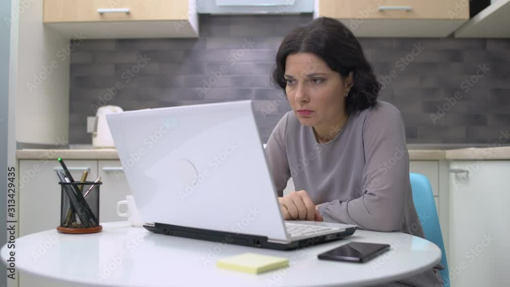 Exhausted business woman typing on laptop at home, feeling tired, lack of energy Exhausted business woman typing on laptop at home, feeling tired, lack of energy
