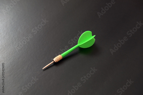 green dart arrow on black background,