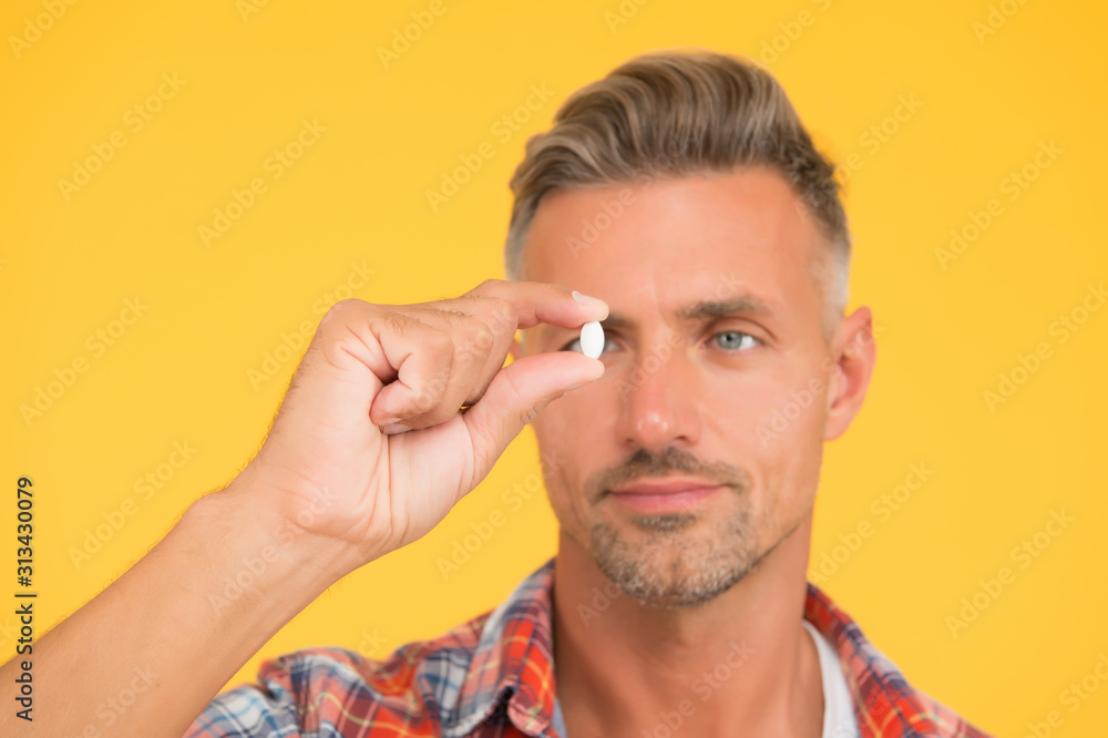unshaven man hold vitamin pill, selective focus. medicine concept. anabolic and steroids. food additives for male health. bio vitamin complex. disease treatment. Presenting product. man look at drug unshaven man hold vitamin pill, selective focus. medicine concept. anabolic and steroids. food additives for male health. bio vitamin complex. disease treatment. Presenting product. man look at drug