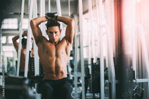 Man bodybuilder lifting dumbbell weights. Man training in a gym Fitness.workout, exercises and healthy concept