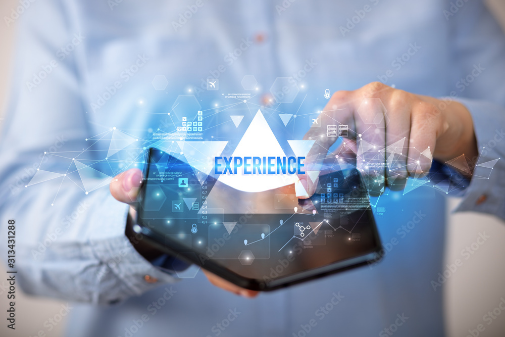 Businessman holding a foldable smartphone with EXPERIENCE inscription, business concept Businessman holding a foldable smartphone with EXPERIENCE inscription, business concept