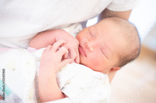 Sleeping newborn baby on father hand