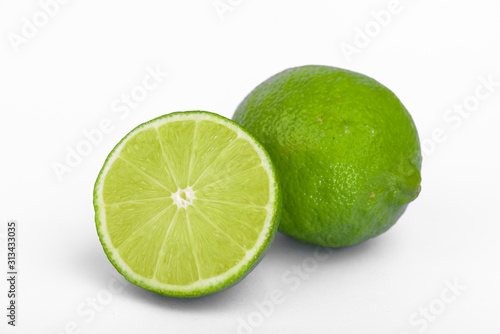 Fresh lime, half and quarter part on white background. Green citrus fruit. 