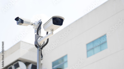 CCTV surveillance security camera video equipment on pole outdoor building safety system area control and copy space photo