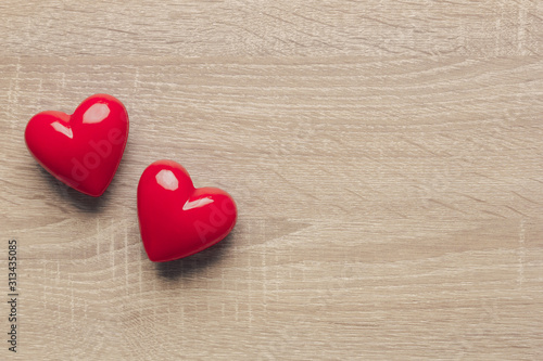 Stock photo of red plastic hearts on a wooden background with space for text