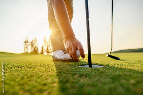 lifestyle, golf, activity, outdoor, sport, golfer concept. Golfers collect golf balls that hole in the green grass on the golf course in the morning.