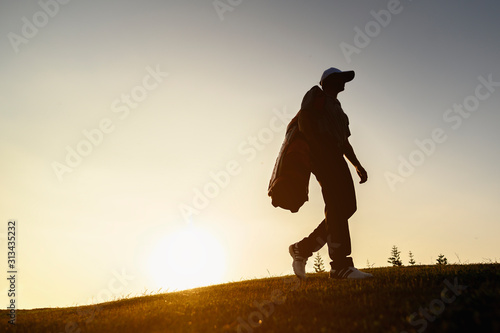 lifestyle, golf, activity, sport, golfer concept A man is carrying a golf bag on a hill at a golf course to practice golfing skills professionally. Sport lifestyle Concept.