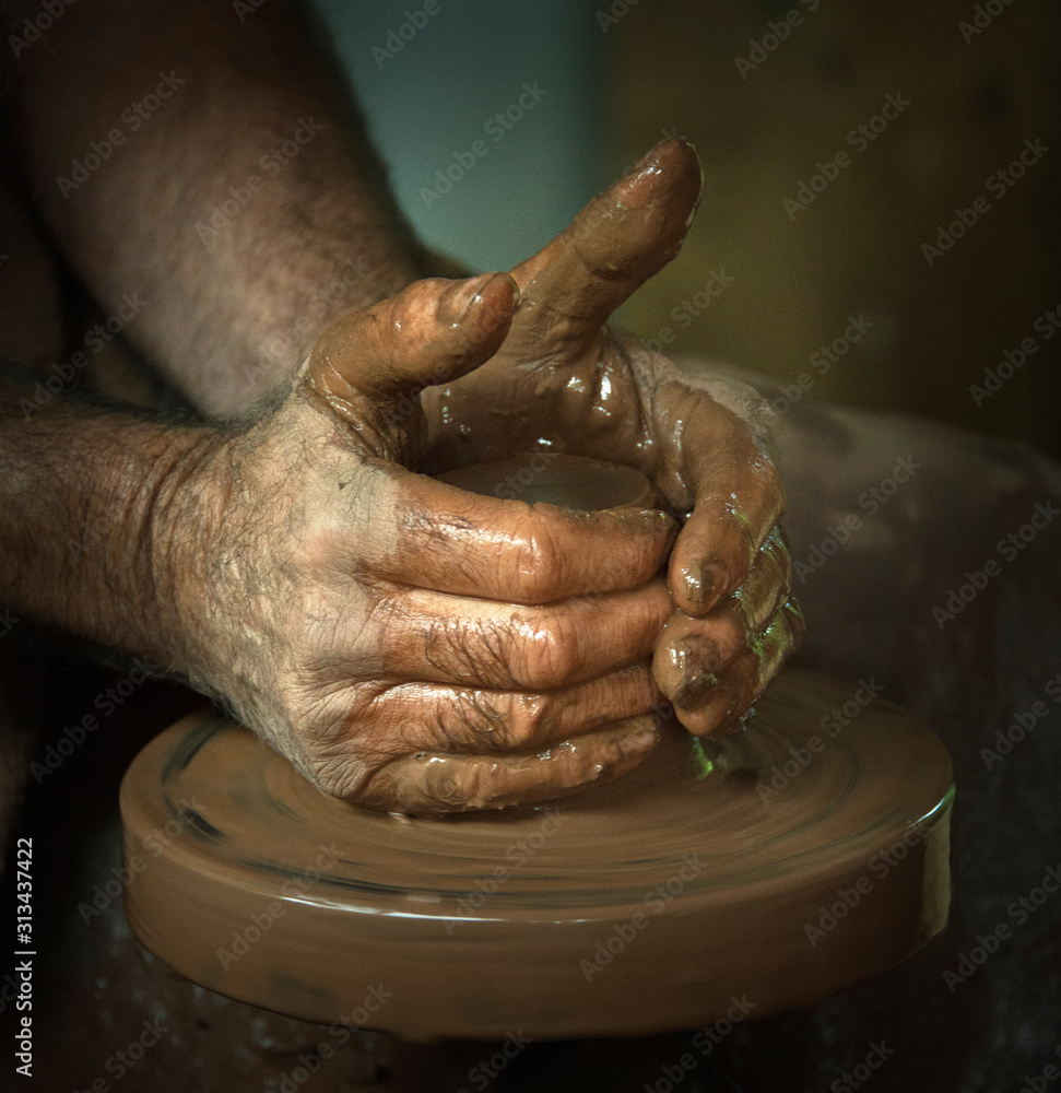 Potters hands moulding wet clay pots 
