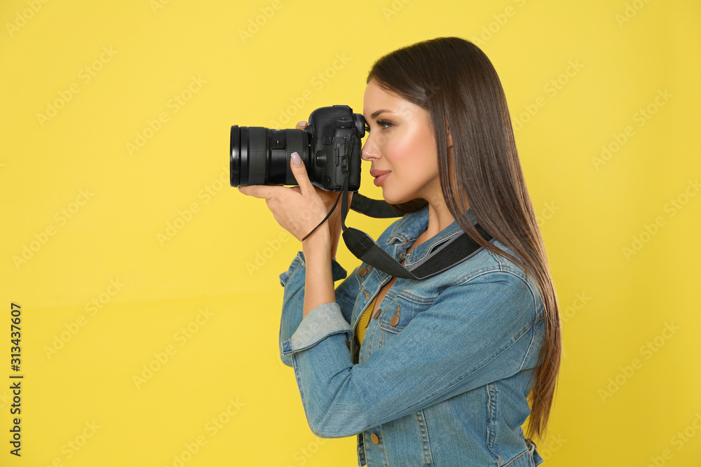 Professional photographer working on yellow background in studio Professional photographer working on yellow background in studio