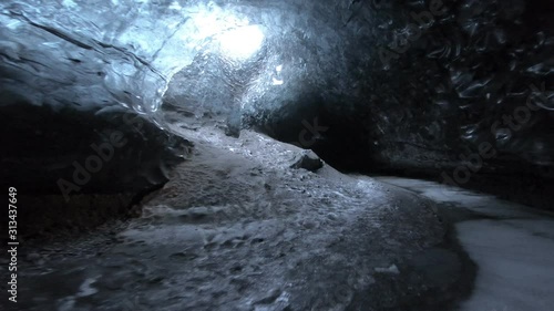 Walking through dark ice caves in Iceland glacier
